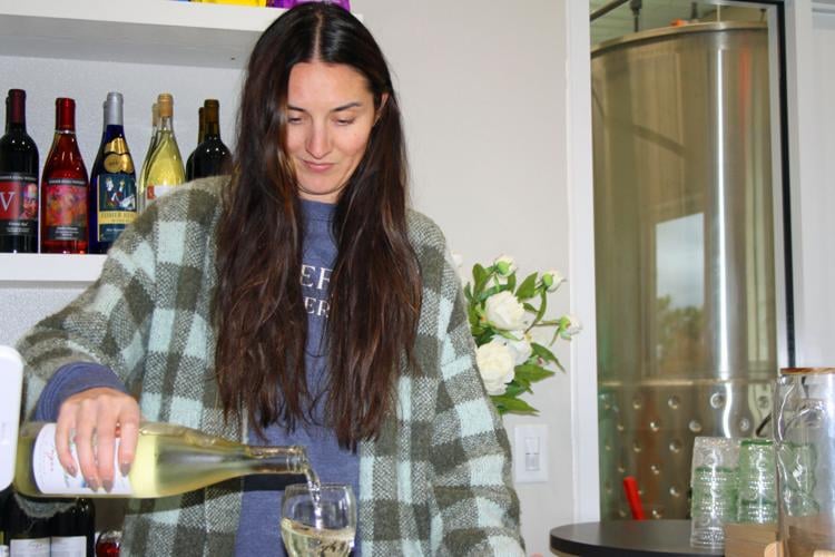 Kelsey pours white wine